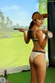 A woman in a bikini holding a golf club.