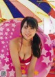 A woman in a red bikini sitting on an inflatable pool float.