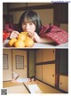 A woman laying on the floor eating a bowl of oranges.