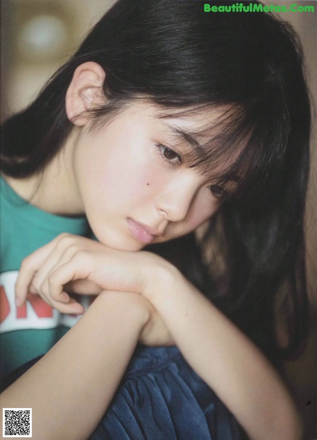 A young woman with long black hair and a blue dress.