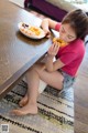 A little girl sitting at a table eating a donut.