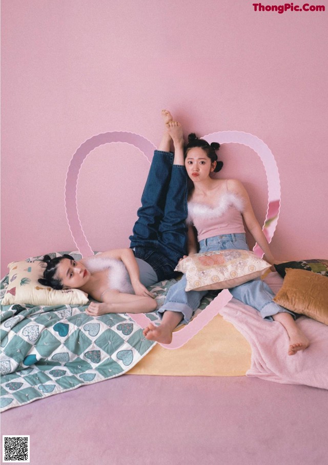 A couple of people laying on top of a bed.