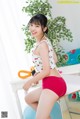 A woman in a white top and red shorts posing for a picture.