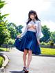 A woman in a blue skirt is walking down the street.