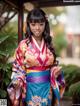 A woman in a colorful kimono posing for a picture.